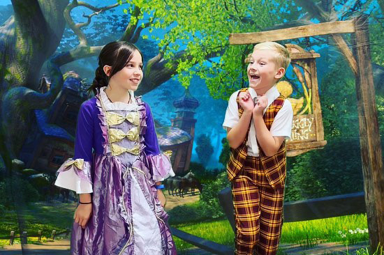 Girl and Boy Acting In Front Of Fairy Tale-Backdrop